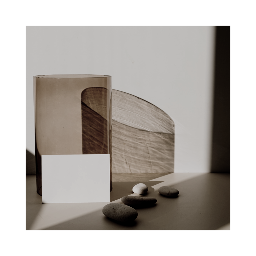Two translucent cylindrical shapes and rocks are sitting atop a table.